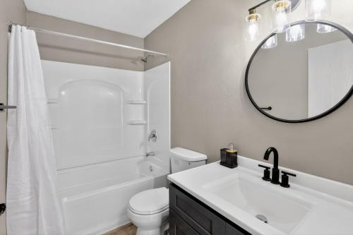 a white bathroom with a sink and a mirror at Contemporary 2BR apartment with workspace in Lenexa