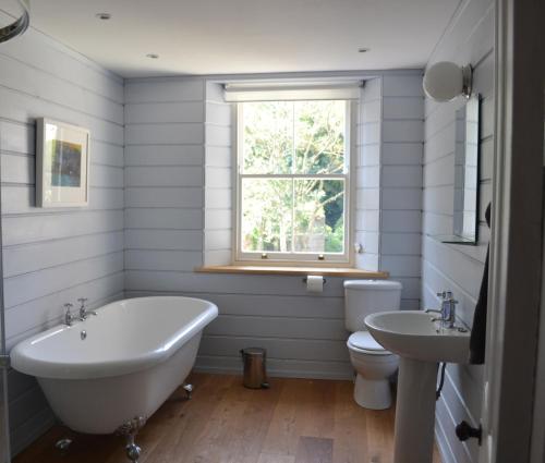 uma casa de banho com 2 lavatórios, uma banheira e um WC. em 8a Spring Gardens em Haverfordwest