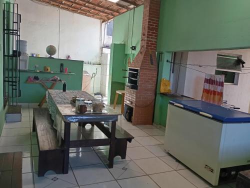 a kitchen with a table and a stove in it at Férias pé na areia, sol e mar in Serra