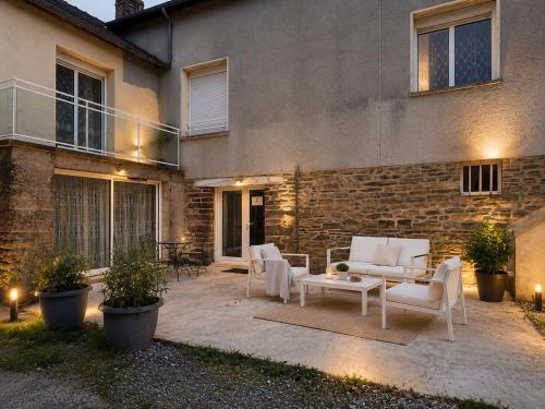a patio with white furniture in front of a building at Appartement T2 à la Campagne 10 min de Rennes in Corps-Nuds