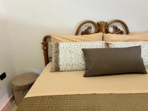 a bed with a wooden headboard and pillows at diamond room in Palmi