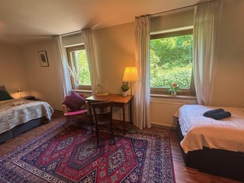 a bedroom with two beds and a desk and a window at Villa Pdorf in Perchtoldsdorf