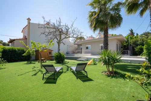 a yard with lawn chairs and a house at Crystal Private Pool House in Artemida