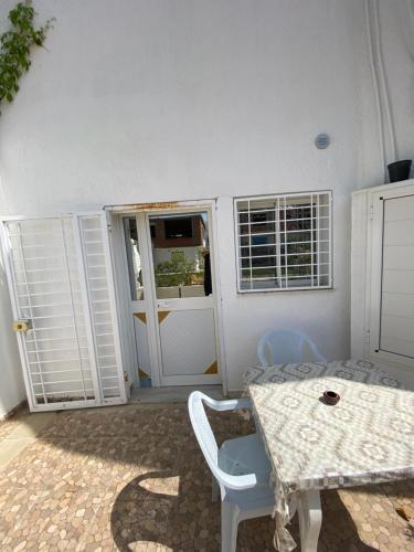 a room with a table and chairs and a door at Mina résidence A0 in Kelibia