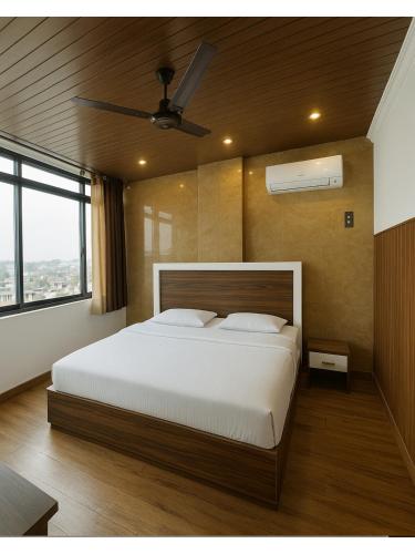 a bedroom with a large bed and a ceiling fan at Hotel Walk Inn in Faridabad