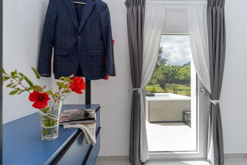 a suit and flowers on a table next to a window at Villa Gisa - Oasi Mediterranea in Calalunga-Pietragrande