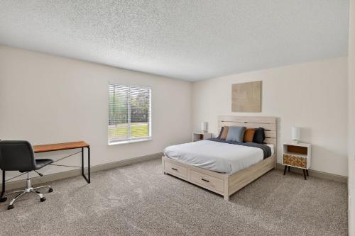 a bedroom with a bed and a desk and a chair at Spacious 2BR stay with updated interiors in Lenexa