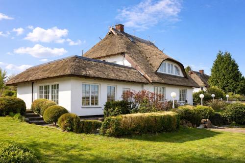 a white house with a thatched roof at FeWo Findling Ruegen in Putbus