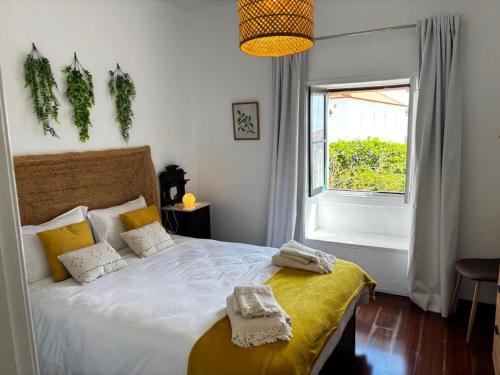 a bedroom with a bed with two towels on it at Casa Jardim 21 in Prazeres