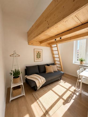 a living room with a blue couch and a ladder at Milada 7 Suits in Brno
