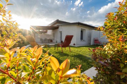 a house with two chairs in the yard at Villa Gisa - Oasi Mediterranea in Calalunga-Pietragrande