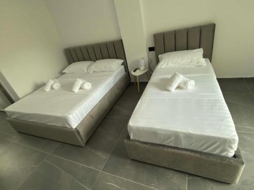 two beds sitting next to each other in a room at Paolo's Apartments in Shëngjin