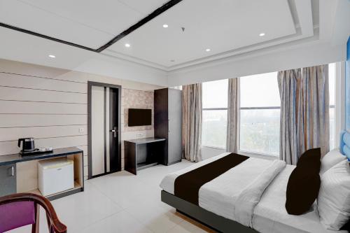a hotel room with a bed and a television at Palette A Lux Corporate Townhouse Near 3 Minutes Kaushambi Metro Station in Ghaziabad