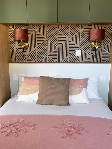 a bedroom with a bed with pink sheets and a headboard at Les logis du canal in Betton