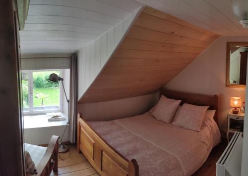 a bedroom with a bed in a attic at Un gîte paisible et frais, piscine à 3 mins in Le Monteil