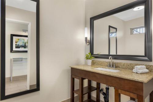 a bathroom with a sink and a large mirror at Best Western Plus Beach View Lodge Carlsbad in Carlsbad