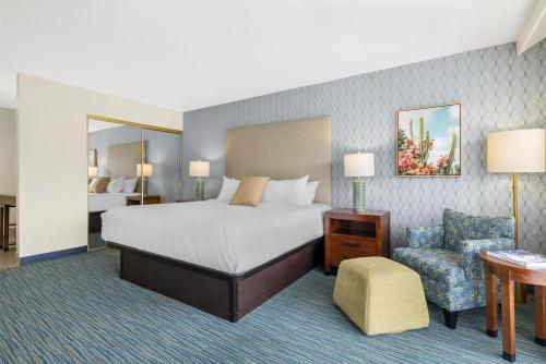 a hotel room with a bed and a chair at Best Western Plus Beach View Lodge Carlsbad in Carlsbad