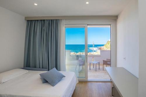 a hotel room with a bedroom with a view of the ocean at Hotel & SPA Riviera Castelsardo in Castelsardo