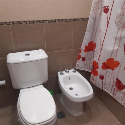 a bathroom with a white toilet and a sink at Rincon de Gulliver in Pinamar