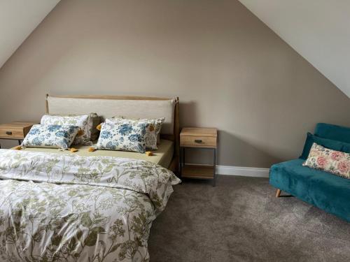 a bedroom with a bed and a blue couch at The loft in Tingewick