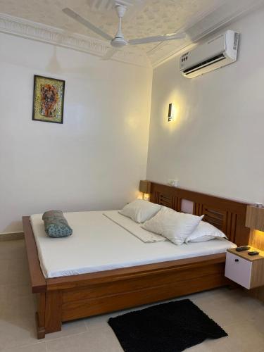 a bed in a room with a white wall at Chic Shop House in Abomey-Calavi