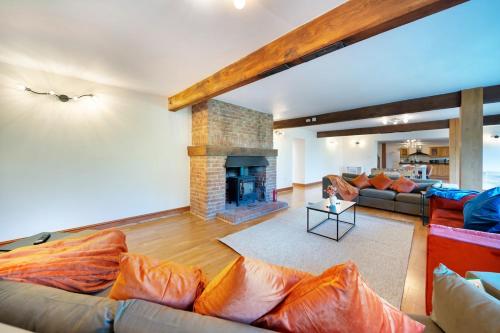 a living room with a couch and a fireplace at Converted Barn - Super King beds, Parking, WiFi in Hockwold cum Wilton
