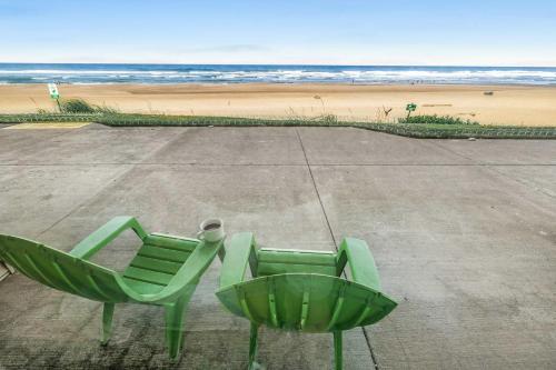 a green chair in front of the beach at Ocean view studio no stairs-Full Kitchen Patio in Lincoln City
