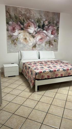 a bedroom with a bed and a painting on the wall at Sogno vesuviano 4 in Torre del Greco