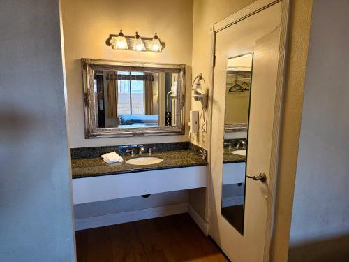 a bathroom with a sink and a mirror at Castaic Inn Six Flags Valencia in Castaic