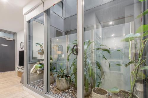 a room with a glass wall with potted plants at The Port Melbourne Experience in Melbourne