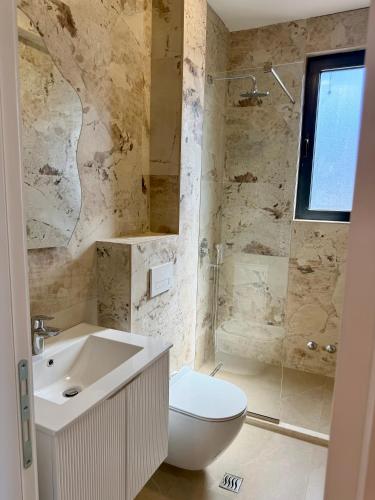 a bathroom with a toilet and a sink and a shower at Maresa 4 in Čanj
