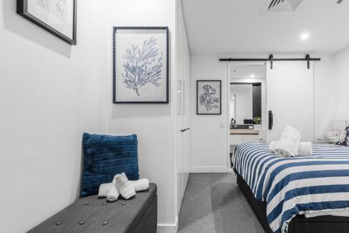 a bedroom with a bed and a blue chair at The Port Melbourne Experience in Melbourne