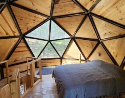 a bedroom in a wooden cabin with a bed in it at Hongos mágicos in San Mateo Río Hondo