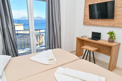 a hotel room with two beds and a balcony at Ikaria Therma Blue in Agios Kirykos