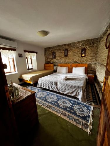 a bedroom with a bed and a stone wall at Guest House Salaria in Gjirokastër