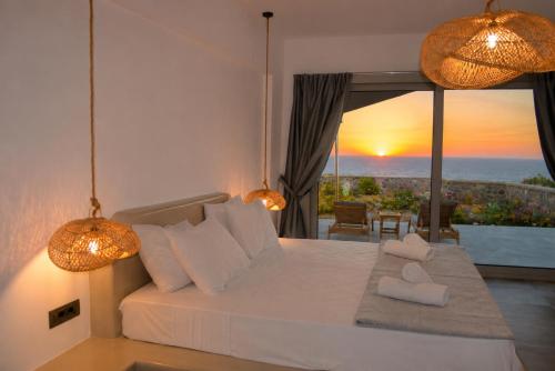 a bedroom with a bed with a view of the ocean at Erimo Vip in Vourvoúlos