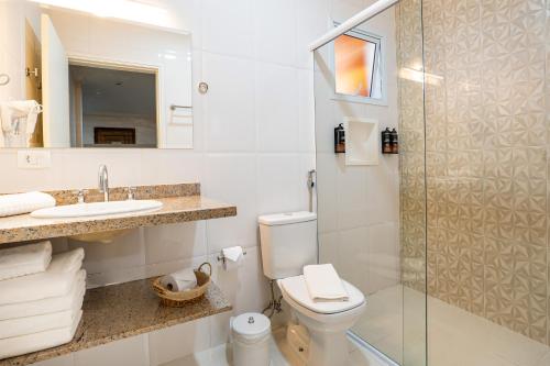 a bathroom with a toilet and a sink and a shower at Pousada Sol da Mantiqueira in Campos do Jordão