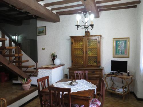 ein Esszimmer mit einem Tisch mit Stühlen und einem TV in der Unterkunft Le Pietre Antiche in Castiglione dʼOrcia