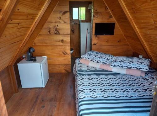 a bedroom with two beds in a wooden cabin at Chalé e Cabana Taubate in Taubaté