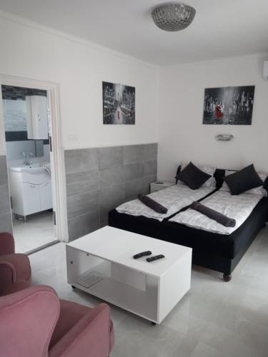 a living room with a bed and a coffee table at Adam Apartman in Hajdúszoboszló