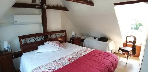 a bedroom with a bed with a red and white blanket at Valérie GOUFFÉ Chambres d'hotes in Parigné-lʼÉvêque