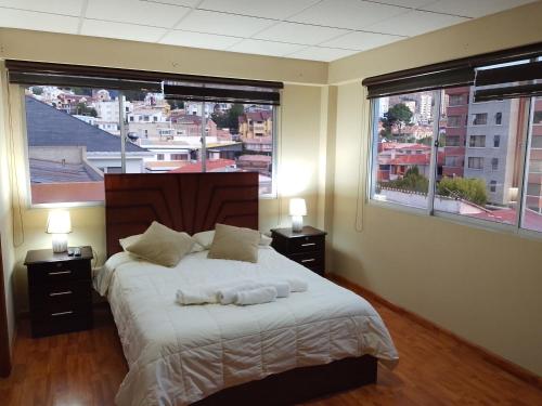 a bedroom with a large bed with two windows at Precioso monoambiente de lujo in La Paz