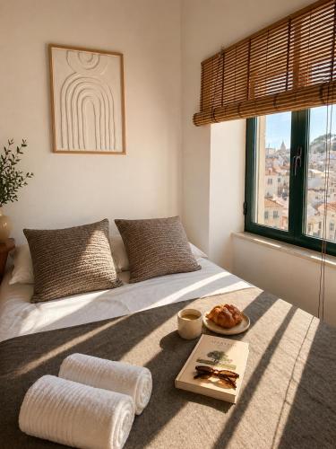 a bedroom with a bed with a tray of food on it at Refúgio No16 Ocean Air & Rooftop Flair in Albufeira
