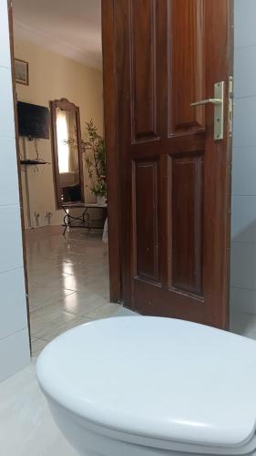 a bathroom with a toilet and a mirror and a door at Providence Guest house and Catering Services 01 in Abidjan