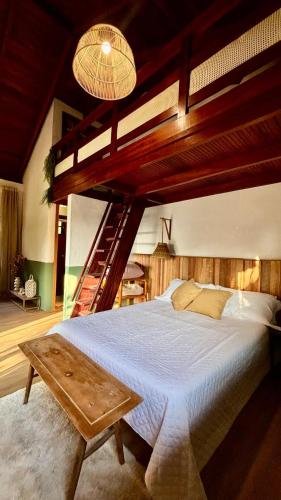 a bedroom with a large bed and a staircase at Chalé na montanha com vista e lareira Mantiqueira in Costas