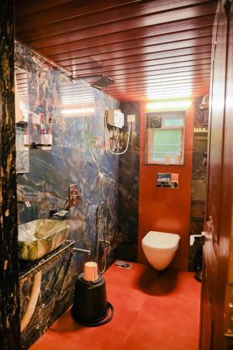 a bathroom with a toilet and a sink at Siddhant Hill Resort in Revadanda