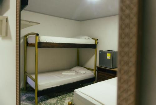 a small room with two bunk beds and a television at VILLA SOL HABITACIONES in San Andrés