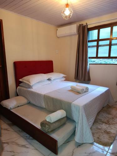 una camera da letto con un grande letto in una stanza di Sítio Do Manacá a Domingos Martins