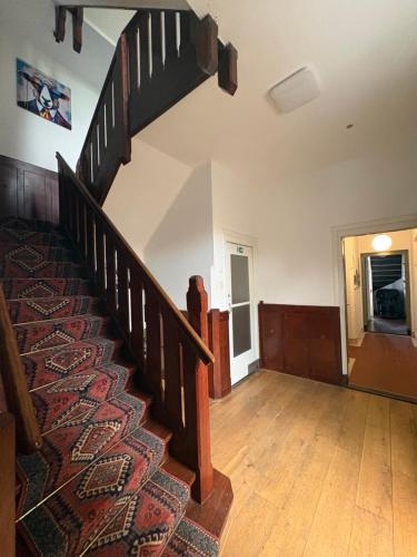 an empty room with a staircase with a rug at Bommelsteijn Lodge in Dordrecht