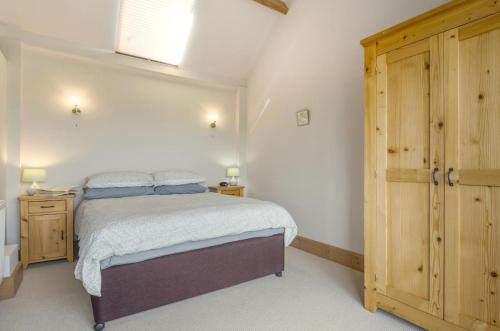 a bedroom with a bed and a wooden cabinet at 1 Bed in Broadway oc-36842 in Broadway